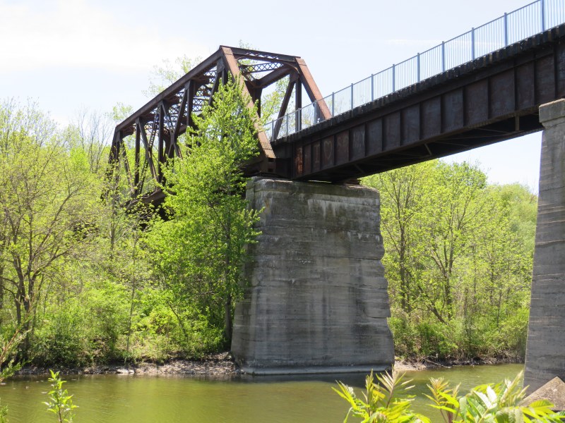 A railway bridge, since converted to a trail, crosses a pond